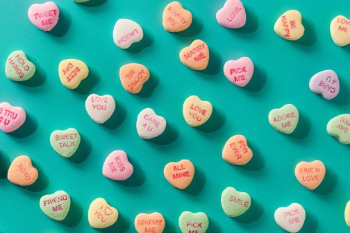 Colorful Candy Conversation Hearts for Valentine's Day on a teal background
